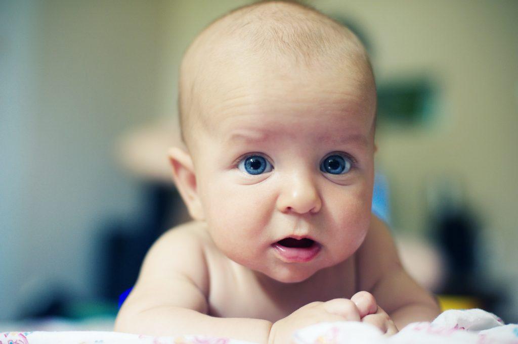 Adorable baby boy crawling in a bedroom