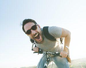Smiling man riding a bicycle