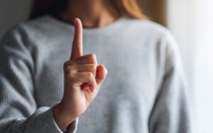 a woman making and showing number one hand sign